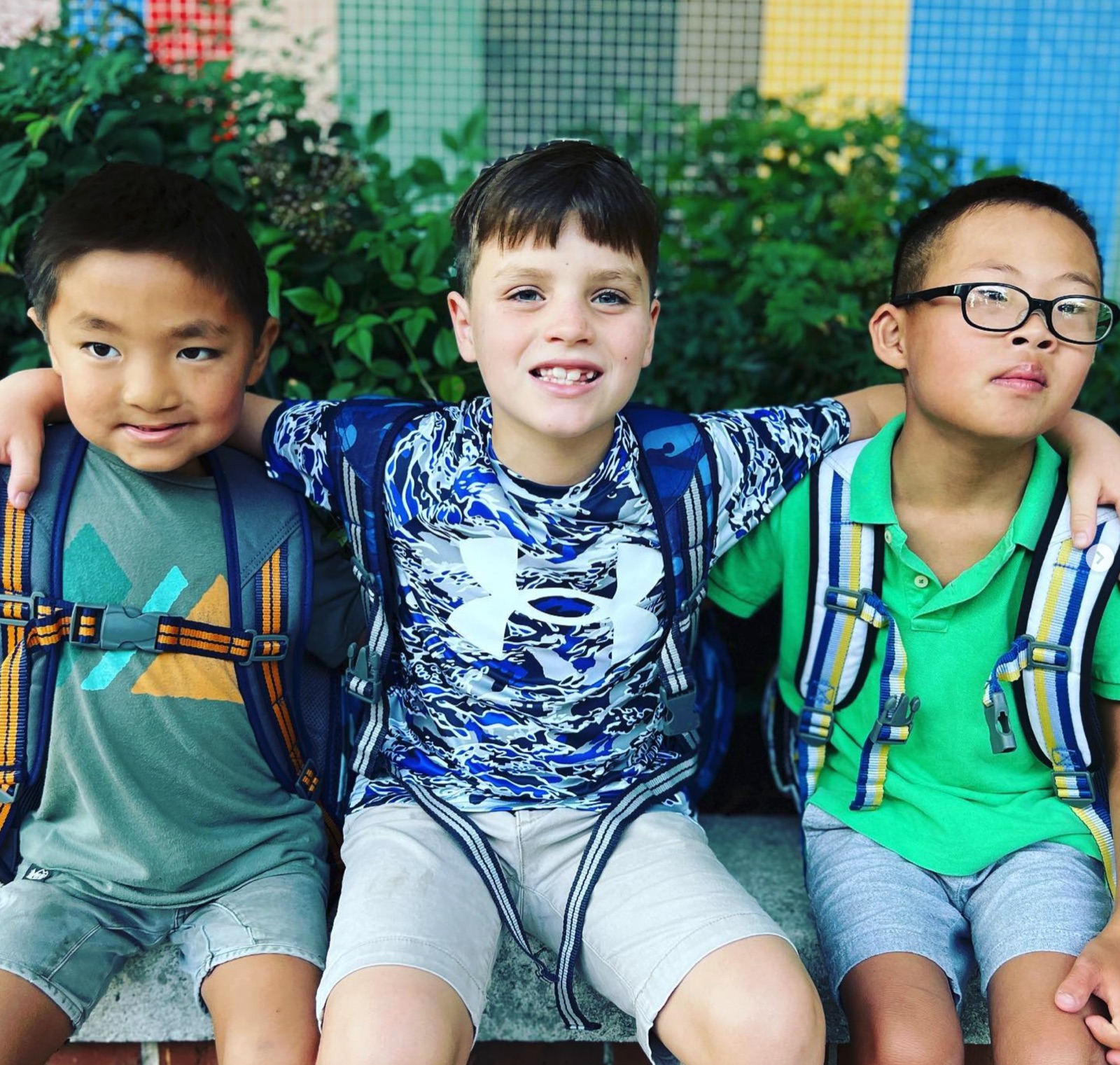 Kai with two friends, arms around each other on the first day of school