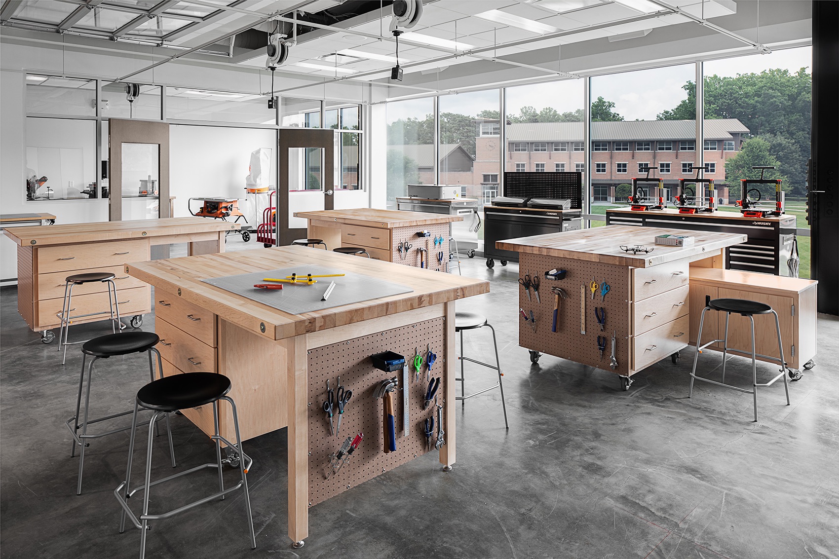 Maker and design engineering lab with worktables, pegboard tools, and 3D printers